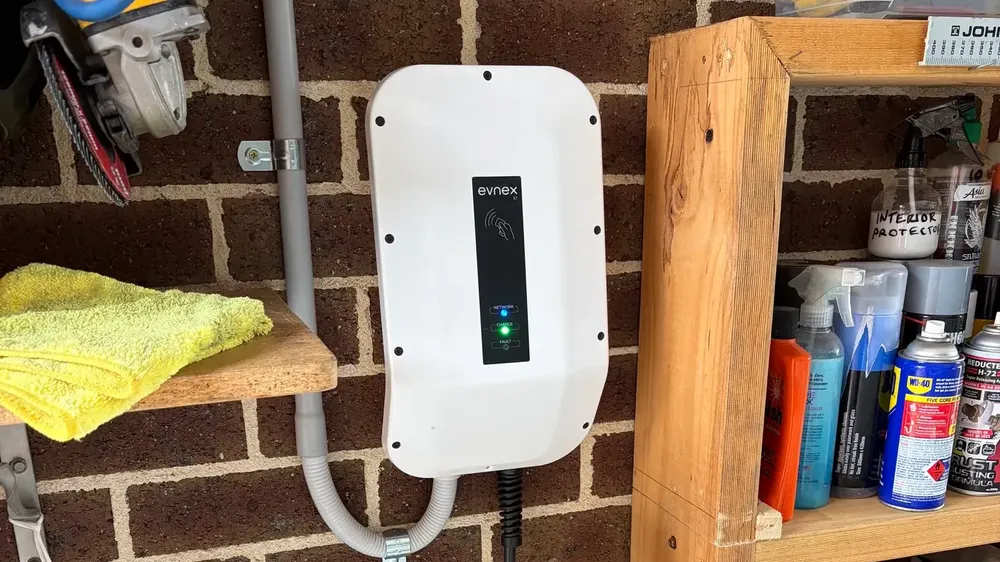 Wall-mounted EV charger installed on the brick wall of a home